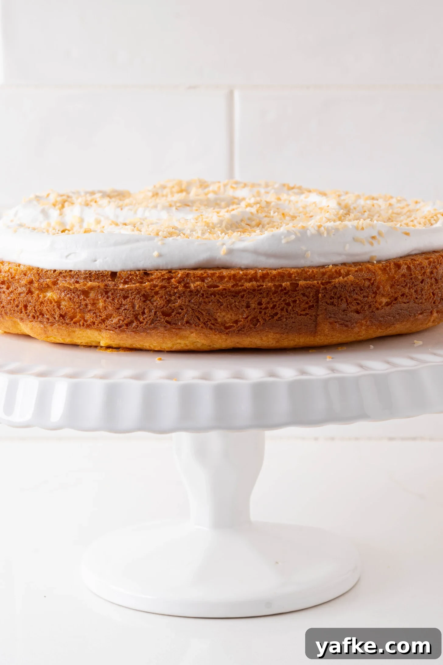 Moist Pina Colada Cake with Caramelized Pineapple 11 A pina colada cake on a cake stand.