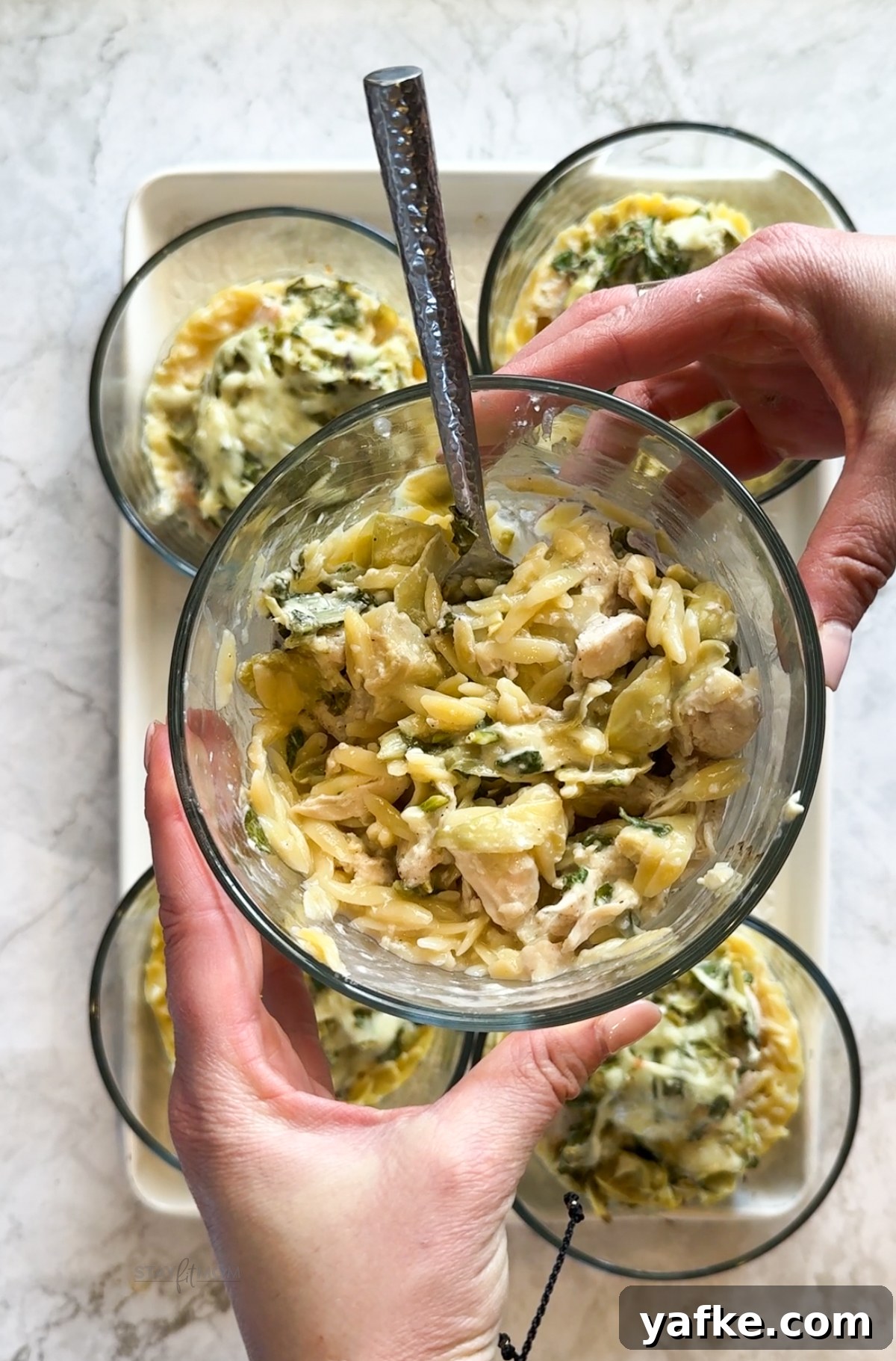 Creamy Spinach and Artichoke Chicken Orzo Bake Recipe 2 Spinach Artichoke Chicken Orzo Bakes with visible chicken breast, orzo, spinach, artichoke hearts, and cheeses.