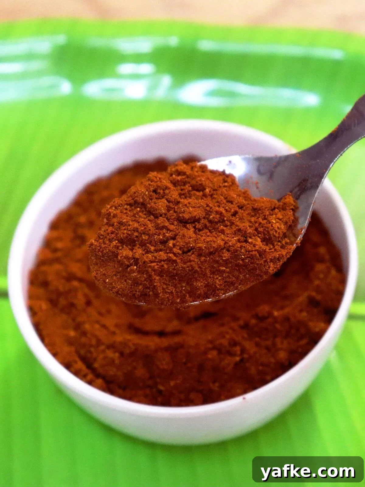 Homemade Madras Curry Powder: Authentic Indian Spice Blend 2 A close-up of Madras curry powder, with a spoonful held over a bowl.