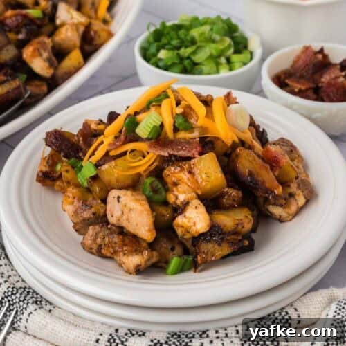 Low-Carb Chicken Recipes for Your Blackstone Griddle 14 A plate of Blackstone Bacon Ranch Chicken, potatoes, cheddar cheese, green onions, and bacon bits