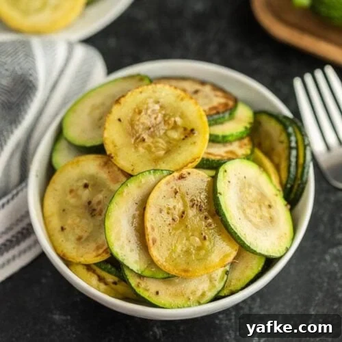 Low-Carb Chicken Recipes for Your Blackstone Griddle 21 A white bowl filled with sautéed slices of Blackstone Zucchini and Squash
