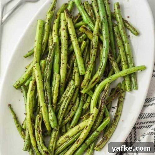 Low-Carb Chicken Recipes for Your Blackstone Griddle 23 Grilled green beans on a white plate.