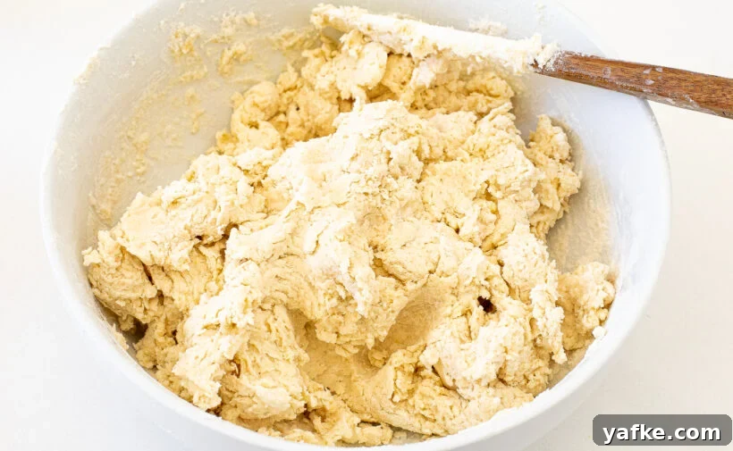 A white bowl filled with raw, mixed dough.