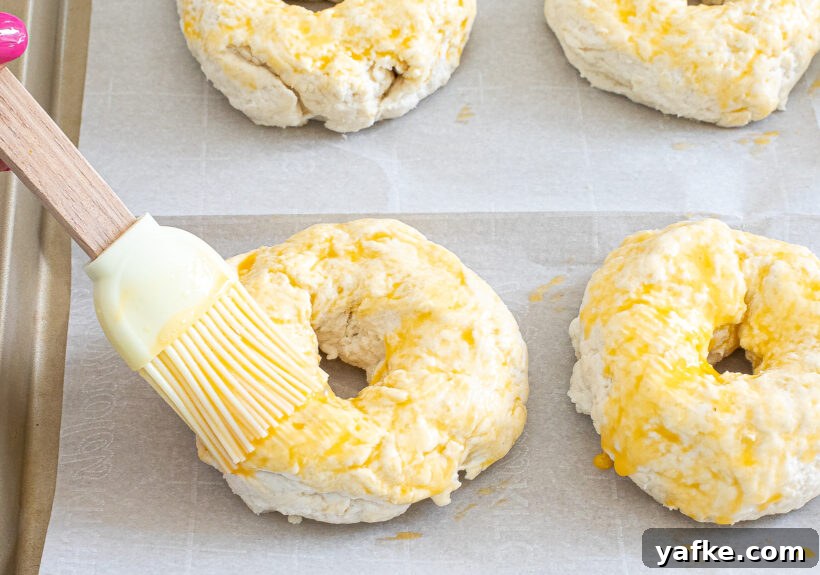 Brushing bagels with egg wash.