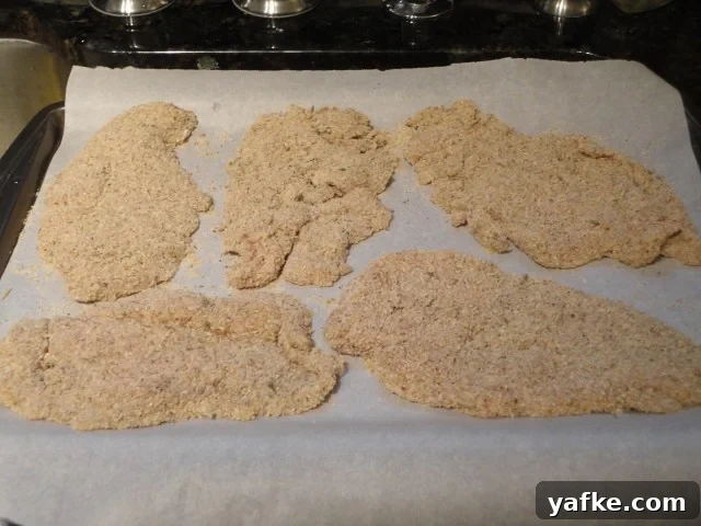 Breaded chicken cutlets on parchment paper
