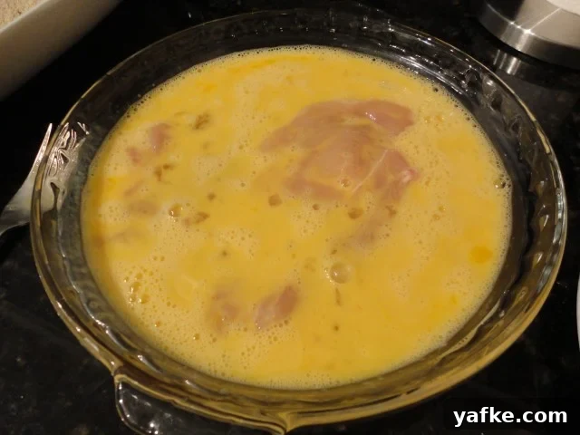 Chicken cutlets soaking in an egg wash