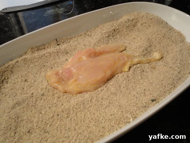 Chicken cutlet with an egg wash pressed into the breading mix